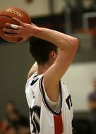teenager in uniform with a basketball at scho