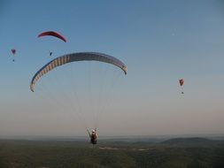 Paragliders in sky at evening