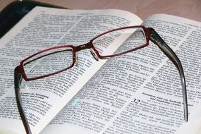 glasses lie on an open bible
