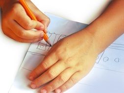 Hands of Kid drawing with pencil on white paper