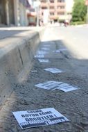 papers with phrases is lying on the sidewalk