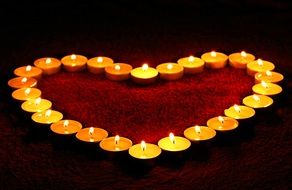 lighted candles laid out in the shape of a heart