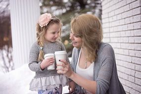 mother and daughter drink tea from thermostat glasses