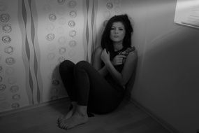woman with weapon sitting in the corner