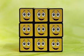 rubik's cube with emoticons on a yellow background