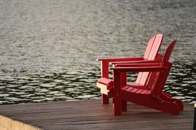 red wooden chairs near the lake