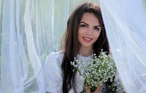 beautiful girl in a white dress with a bouquet