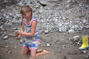 child playing in the water on the beach