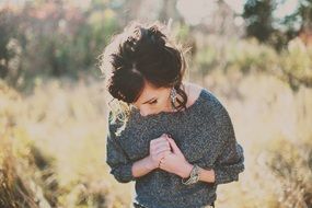 girl on green grass looks down