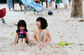 Smiling Children are playing with the sand