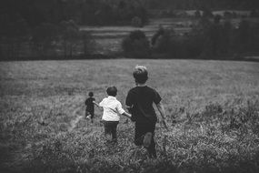 boys playing in the field in black and white