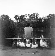 young man on a bench in black and white background