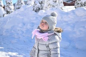 girl in a down jacket among snowy nature