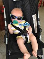 baby in sunglasses in a stroller