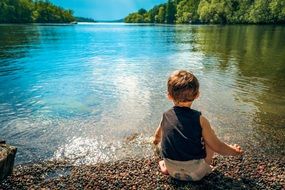 child plays on the lake