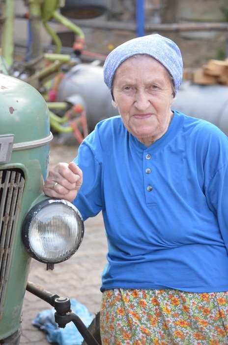 old caucasian woman on farm at vehicle