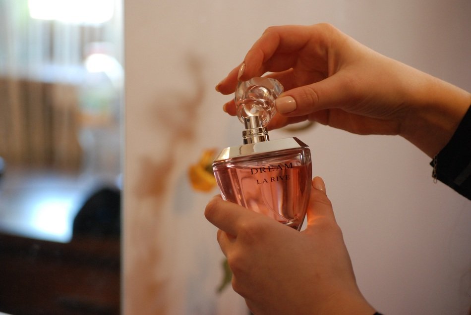 bottle with Perfume in Womanâs hands