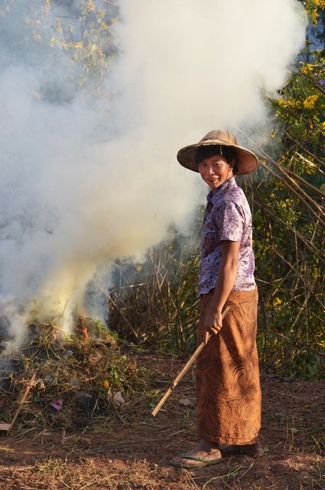 woman on the farm burns grass