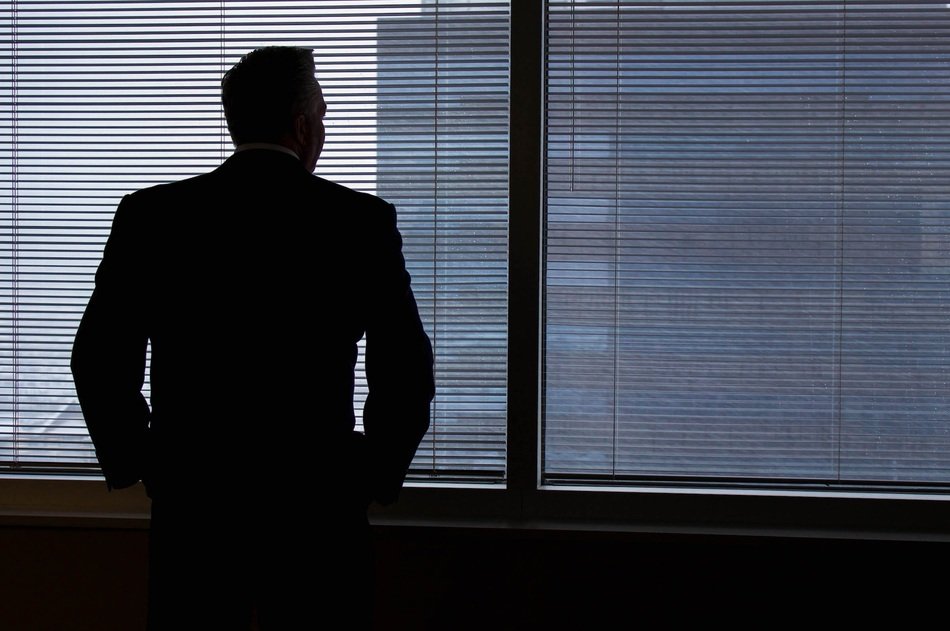 silhouette of businessman near window in office