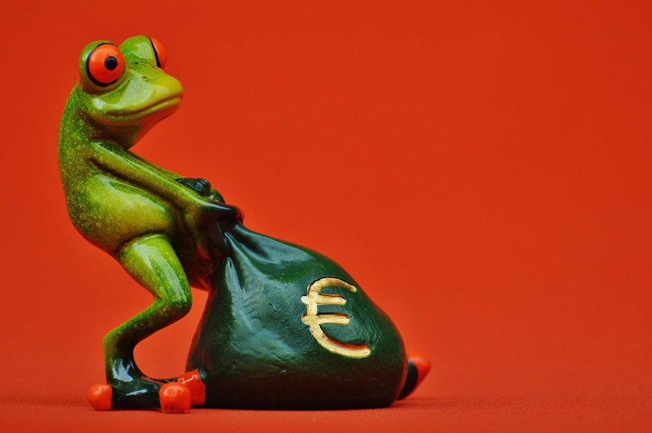 ceramic frog with bag on orange background