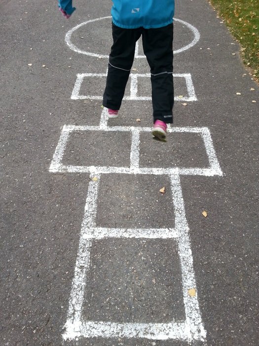 dild plays hopscotch on asphalt