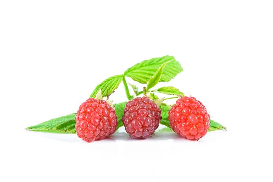 three Ripe Raspberries and leaves at white background