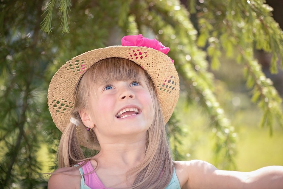 smiling girl in straw hat on wood background