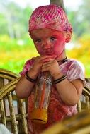 Boy in the paint is drinking juice