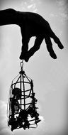 human hand is holding cell with reduced human skeleton in