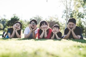 happy asian Family with three kids lying on grass