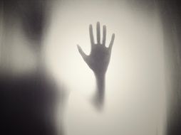 silhouette of hands on glass