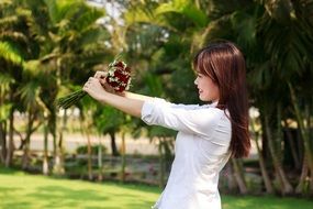 beautiful smiling asian Girl with Flowers in hands