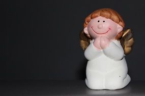 ceramic angel figurine on a black background