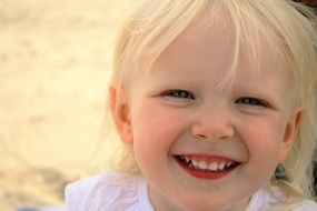 portrait of a smiling little girl with blond hair