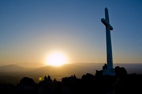 people on hill near cross at sunrise, easter service