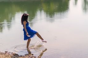 happy girl stands in the water near the shore