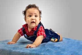 child in overalls in a photo studio