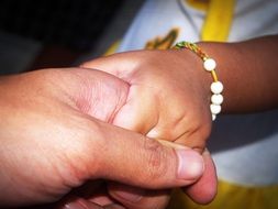 child's hand in the hands of an adult