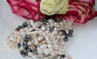 pearl necklace near a bouquet of roses