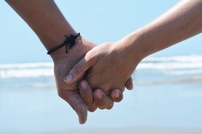 hands of a couple in love on the beach