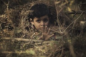 Child boy stretching Hand from pile of forest floor