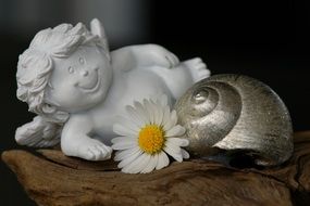 garden angel figurine near chamomile