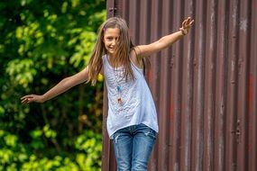 little girl plays near the fence