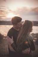 Couple is kissing near the water