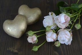 two stone hearts near a bouquet of roses