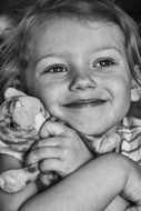 black and white photo of a child hugging a puppy