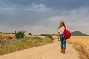 girl with a backpack on a deserted road