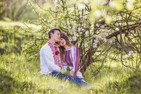 loving couple in embroidered shirts in spring garden