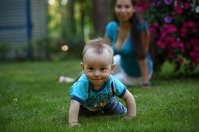 baby crawling on the green grass