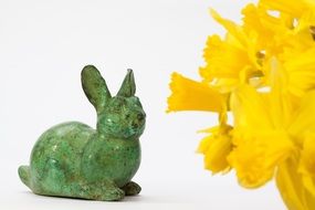 green figure of easter bunny and yellow daffodils